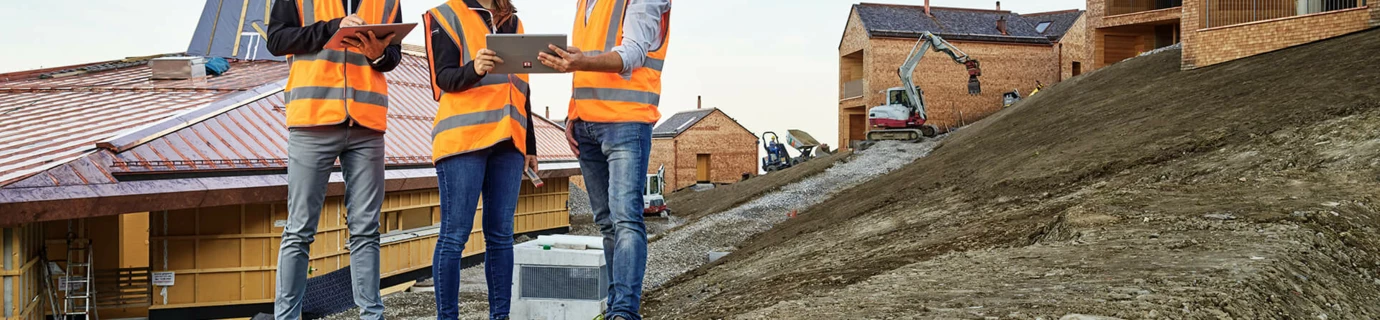 General- und Totalunternehmer Rhomberg Bau 2 Menschen stehen vor Baugerüst