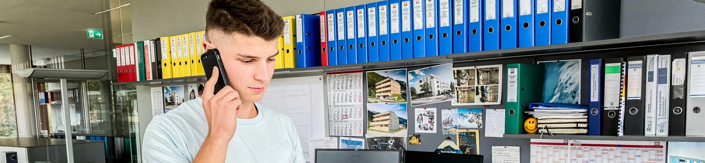 Luca Bauleiter bei Rhomberg Bau im Büro vor Tablet am Telefon