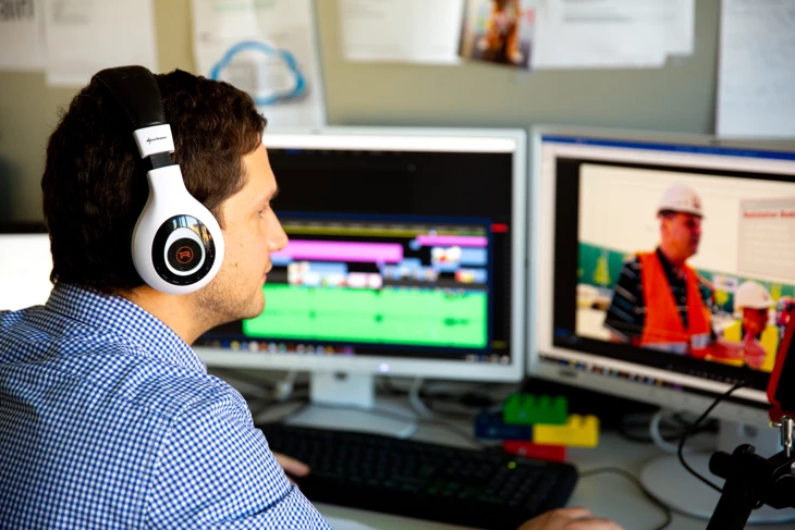 Marcel Milohnic wie er in seinem Büro ein Video am Computer bearbeitet