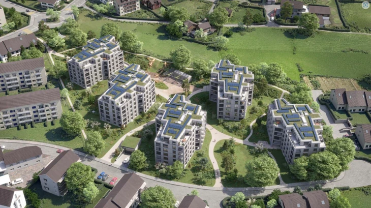 Luftbild von mehreren modernen Wohngebäuden mit Solaranlagen auf den Gründächern und umliegenden Grünflächen (Uster).