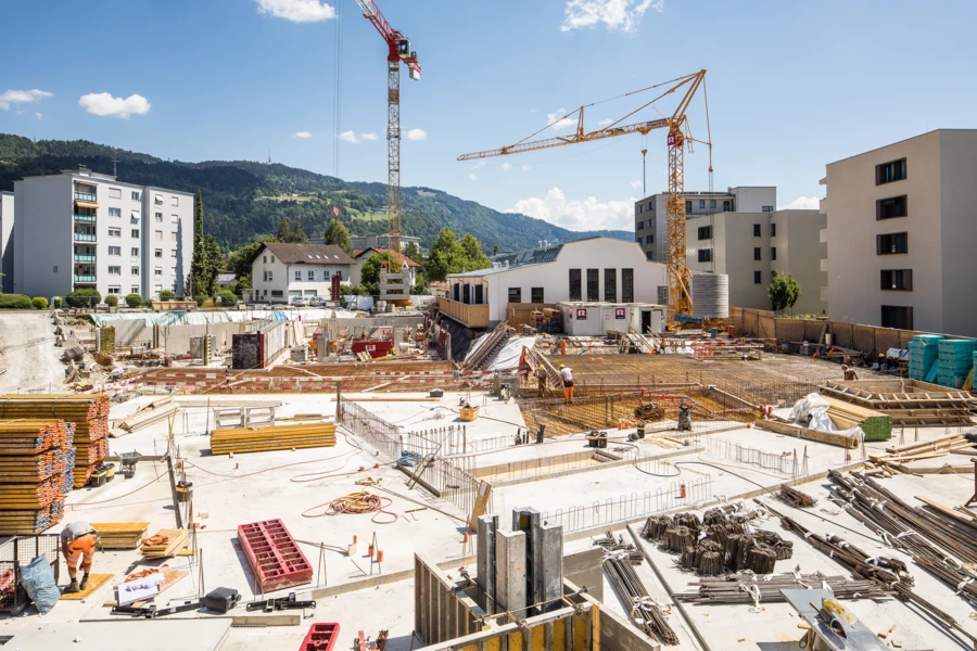 Gesamtübersicht Baustelle mit vielen Geräten und zwei Kränen