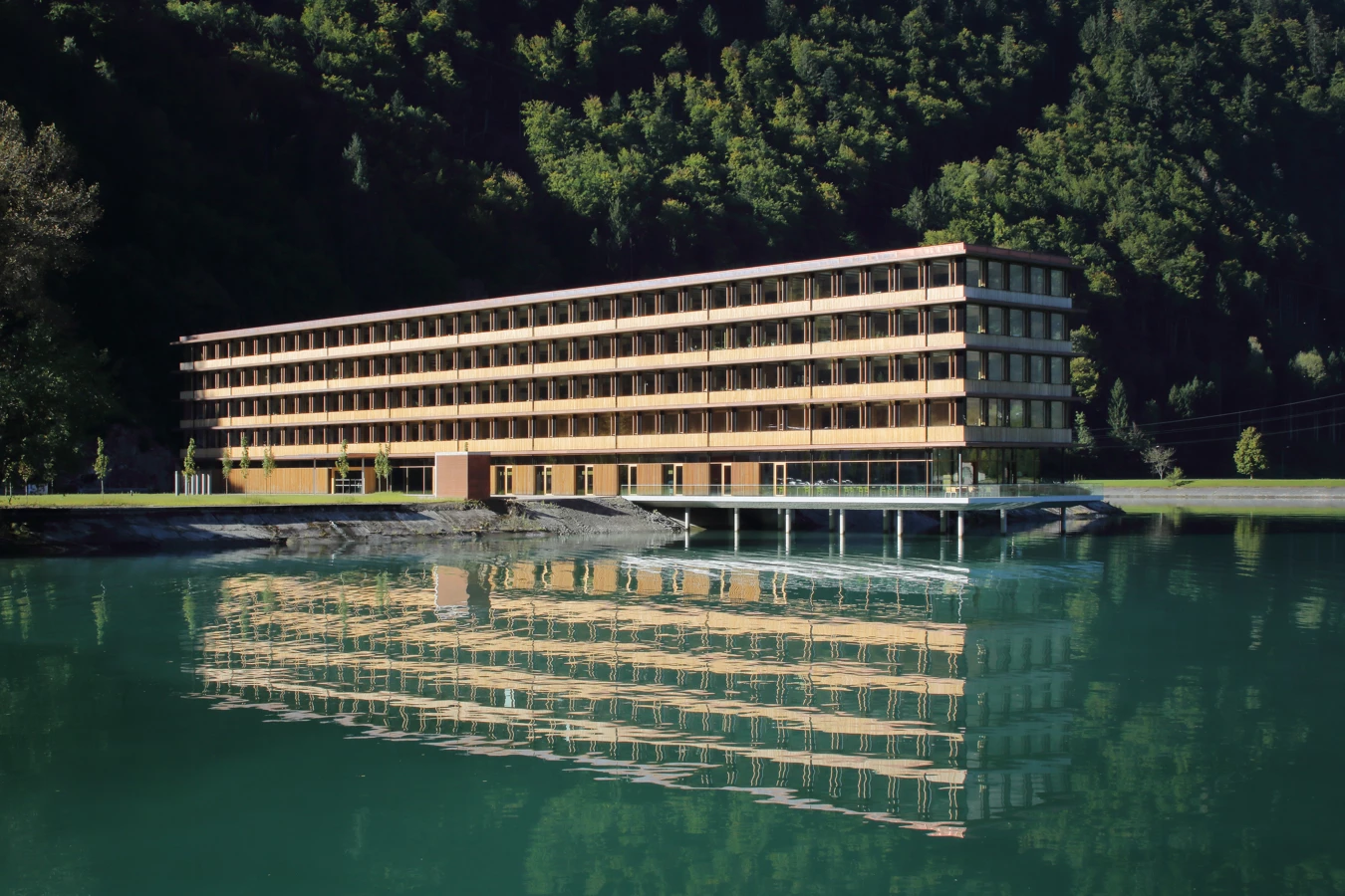 Holz- und Systembau Illwerkezentrum Montafon Rhomberg Bau Aussenansicht mit Gewässer Holz- und Systembau Illwerkezentrum Montafon Rhomberg Bau Aussenansicht mit Gewässer